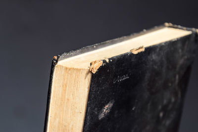 Close-up of old book on table against black background