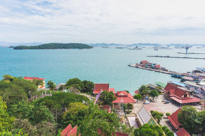 High angle view of city by sea against sky