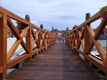 Footbridge over wooden bridge against sky