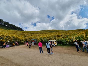 Group of people on landscape against sky