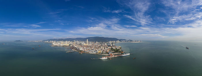 High angle view of cityscape by sea against sky