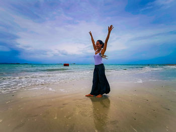 Beautiful asien woman standing at beach against sky