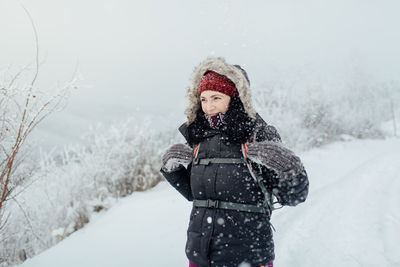 Young woman standing on snow covered landscape during winter