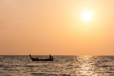 Silhouette boat in sea against sky during sunset