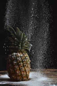 Close-up of fruit on table against black background