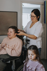 Mother braiding daughter's hair