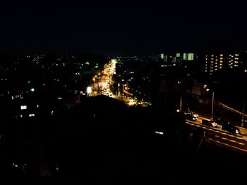 Illuminated cityscape against sky at night