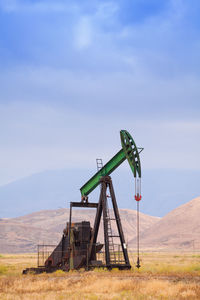 Windmill on field against sky