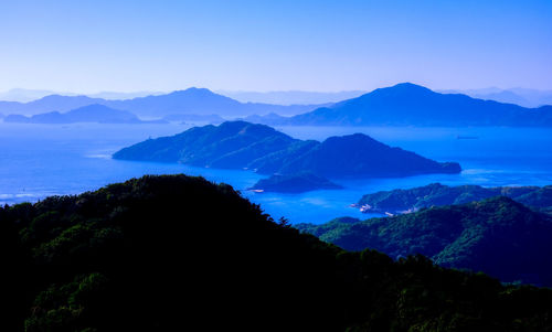 Scenic view of silhouette mountains against blue sky