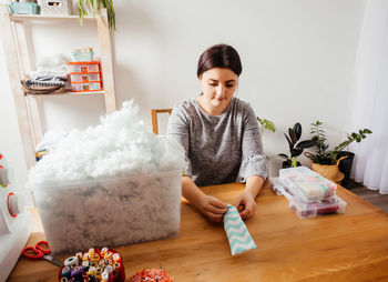 Young woman sitting on table at home