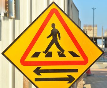 Close-up of pedestrian crossing safety sign on road