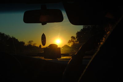 Close-up of car on road against sunset sky