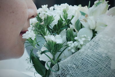 Close-up of woman smelling white flowers