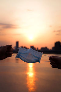 People holding orange sky during sunset