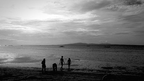 People enjoying at beach against sky