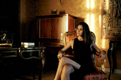 Young woman sitting on chair in room