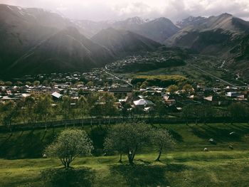 Scenic view of field and houses against mountains
