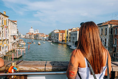 Rear view of woman looking at canal in city