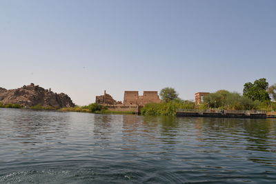 River by buildings against clear sky