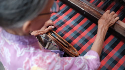 Midsection of woman working on loom