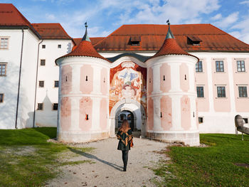 People in front of building against sky in city