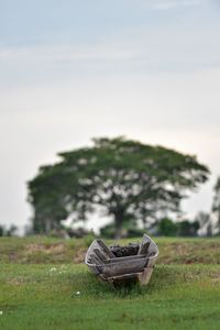 Close-up of shoes on field against sky