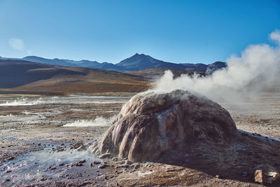 Smoke emitting from volcanic mountain against sky