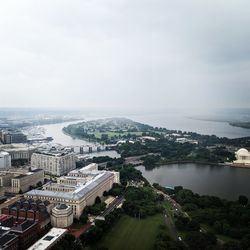 High angle view of townscape by sea against sky