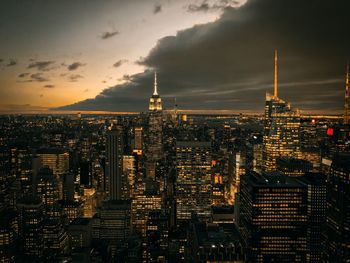 Illuminated modern buildings in city against sky