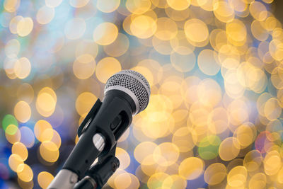 Close-up of microphone against illuminated lights