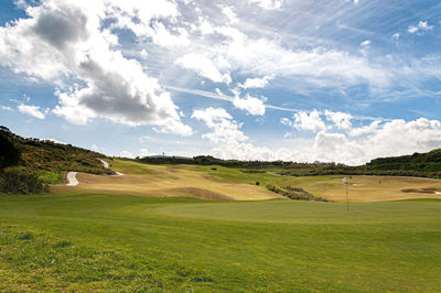 Scenic view of golf course against sky