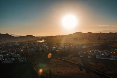 High angle view of illuminated city against sky at sunset