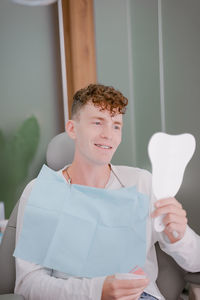 After installation by the orthodontist, he looks in the mirror at the braces