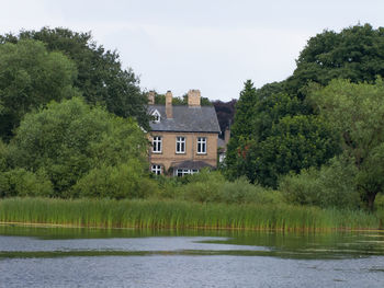 River by trees against sky