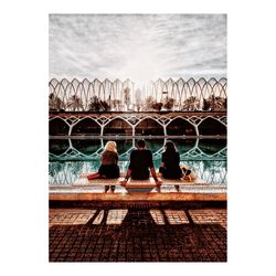 People sitting by swimming pool against sky