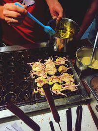 Close-up of person preparing food on barbecue grill