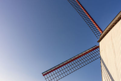 Low angle view of crane against clear blue sky