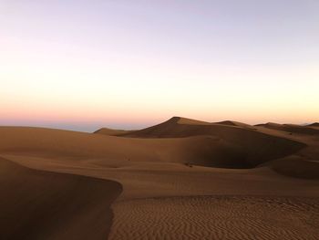 Scenic view of desert against sky during sunset