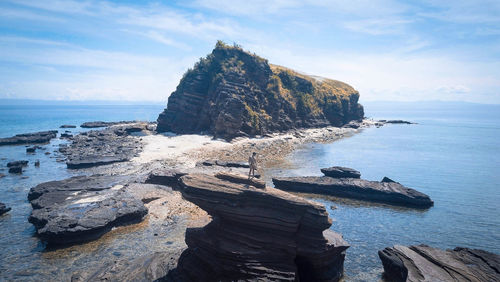 High angle view of man standing on rock formation at beach