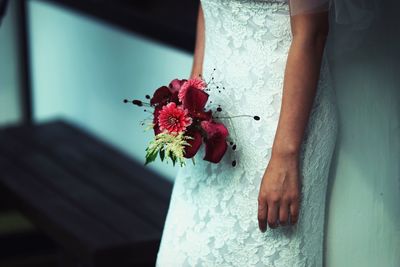 Close-up of hand holding red flower