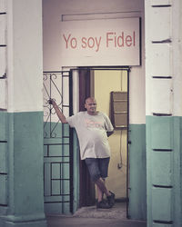 Portrait of man standing against door