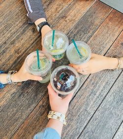 High angle view of woman holding beer glass on table