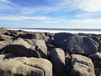 Rocks on beach against sky