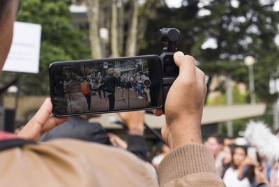 Midsection of man photographing with mobile phone