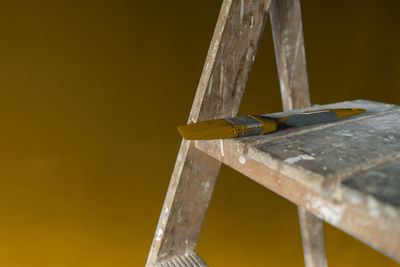 Close-up of metallic structure against yellow background