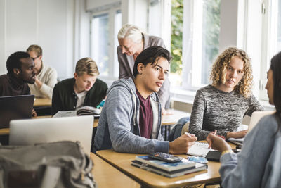 Group of people using phone while sitting on table