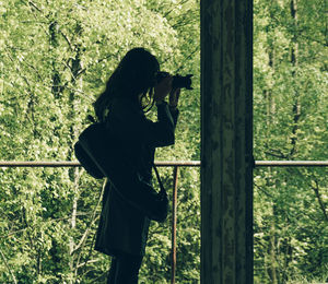 Side view of man photographing through camera