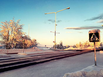 Snow covered street against sky during winter