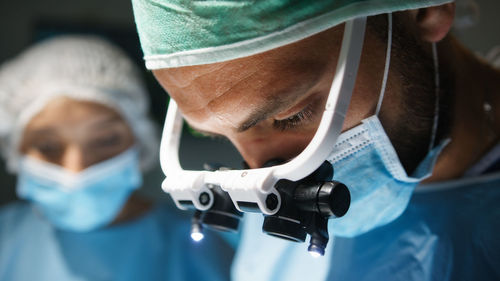 Cardiac surgeon with surgical headlamp operates at a heart stent