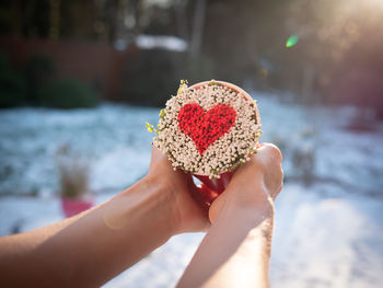 Midsection of woman holding heart shape